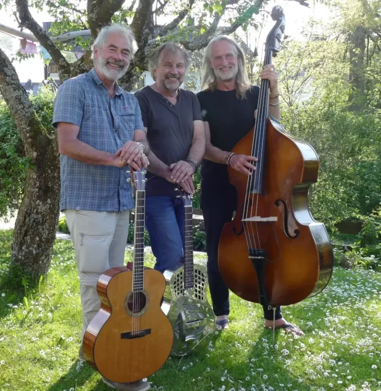 Mit akustischen Instrumenten und ausdrucksstarken Stimmen entführt das Trio Open Range sein Publikum in die weite Klanglandschaft von Blues und Folk. Uli Roidl (Gitarre, Bluesharp, Gesang), Bernhard Steinmetz (Gitarre, Slide-Guitar, Foot-Percussion, Gesang) und Martin Baldauf (Kontrabass, Gesang) interpretieren Klassiker und Raritäten in eigenen, besonderen Arrangements – mal feinfühlig, mal kraftvoll, aber stets mit viel Gefühl und einem großen Gespür für den Moment. Der Bandname Open Range steht dabei sinnbildlich für die musikalische Freiheit, die sich das Trio nimmt: Improvisation, kreative Wendungen und überraschende Momente sind Teil jedes Auftritts. Gespielt wird, was den Musikern selbst Freude bereitet – und genau diese Begeisterung überträgt sich auf das Publikum. Das Repertoire ist ebenso abwechslungsreich wie stimmungsvoll: von Blueslegenden wie Robert Johnson und Elmore James über die Allman Brothers bis hin zu Songs von Eric Clapton, Fleetwood Mac, Van Morrison, Pink Floyd, den Rolling Stones und U2 – Open Range spannt einen klangvollen Bogen von den Wurzeln des Delta-Blues bis zu Klassikern der letzten Jahrzehnte.