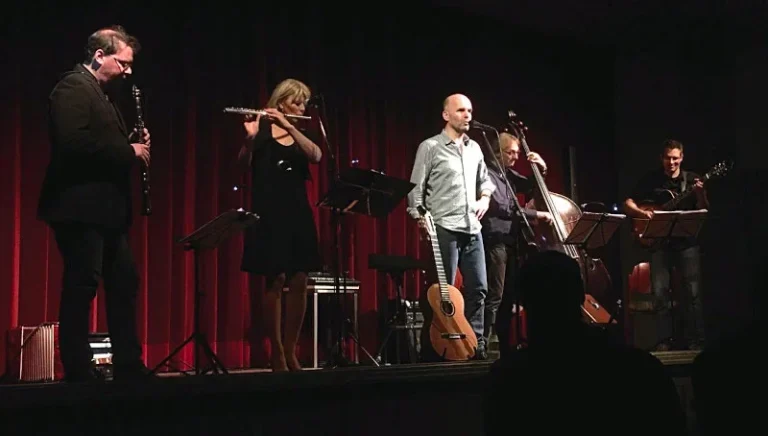 „Chansons d’amour … et d’automne“, das ist ein Abend mit Chansons von Brassens, Gainsbourg, Trenet, Biolay und anderen, dargeboten in neuen, ganz eigenen Coverversionen – der Franzose sagt „reprises“. Klassiker des Chansons sind ebenso dabei wie hierzulande Unbekanntes, meist herbstlich melancholisch und dabei erfrischend fern von Baskenmützenklischees und Musetteromantik. Ausgefeilte Arrangements, immer wieder durchbrochen von ungezügelter Spielfreude, zelebriert von vier versierten Jazzmusikern und einem Sänger, der weiß, was er tut. Das Ergebnis ist groovende Kammermusik, die mitreißt und begeistert, mit klugen Texten, die man gar nicht unbedingt im Original verstehen muss, denn Edelmann gibt den launigen Conférencier, der auch die sprachlich Unkundigen im Publikum humorvoll mitnimmt, auf die Reise durch seine Lieblingschansons. Oder, wie es die Presse einmal formulierte: „Ein buntes, delikates Programm, vor dem man keine fremdsprachige Schwellenangst haben muss. Geeignet für Frankophile und (als Therapie) -phobe.“